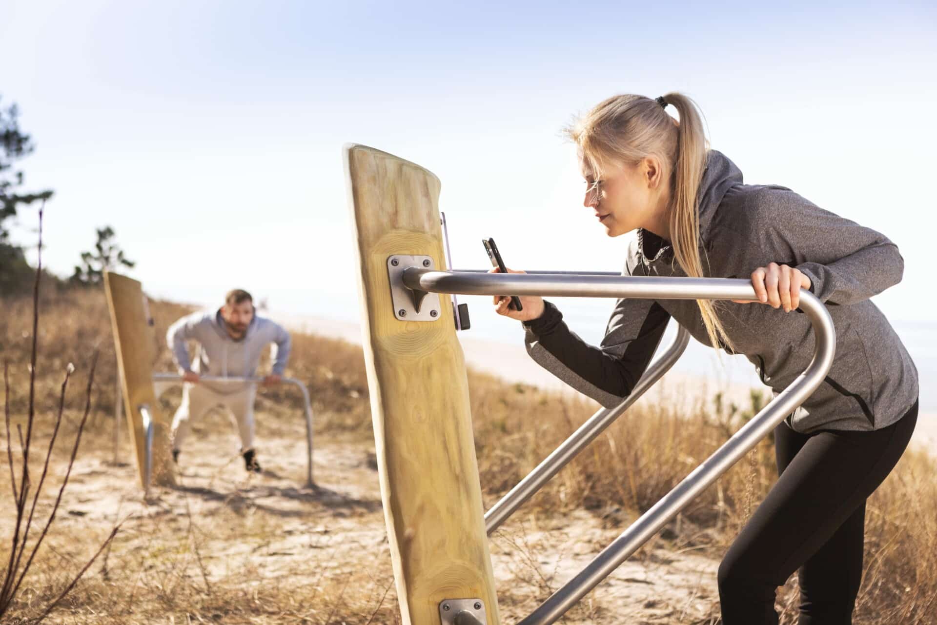 Outdoor fitness toestel vrouw sport in duinen